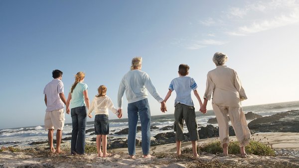 Eine Familie mit mehreren generationen am Strand, Hand in Hand