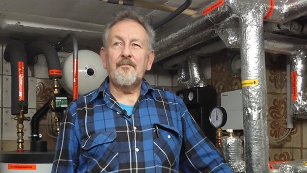 erfahrungsbericht wärmepumpe illing Mitglied Wilhelm Illing steht im Heizungskeller vor seiner neu eingebauten Wärmepumpe