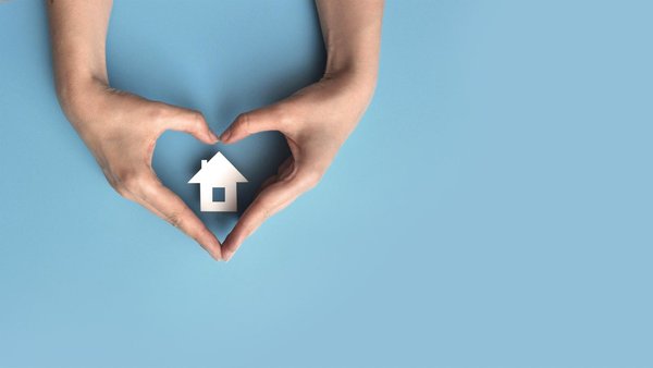 Blauer Hintergrund, mit Händen die ein Herz formen