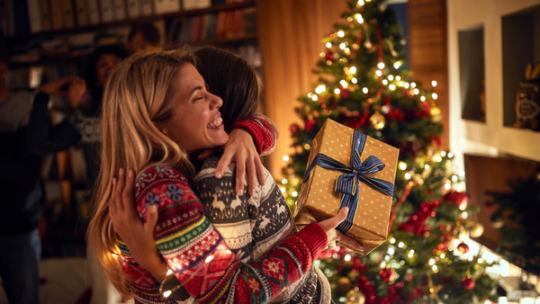 Eine Person freut sich an Weihnachten darüber, eine Mitgliedschaft beim Verband Wohneigentum NRW als Geschenk bekommen zu haben.