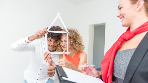 Paar bei einer Hausbesichtigung mit Maklerin